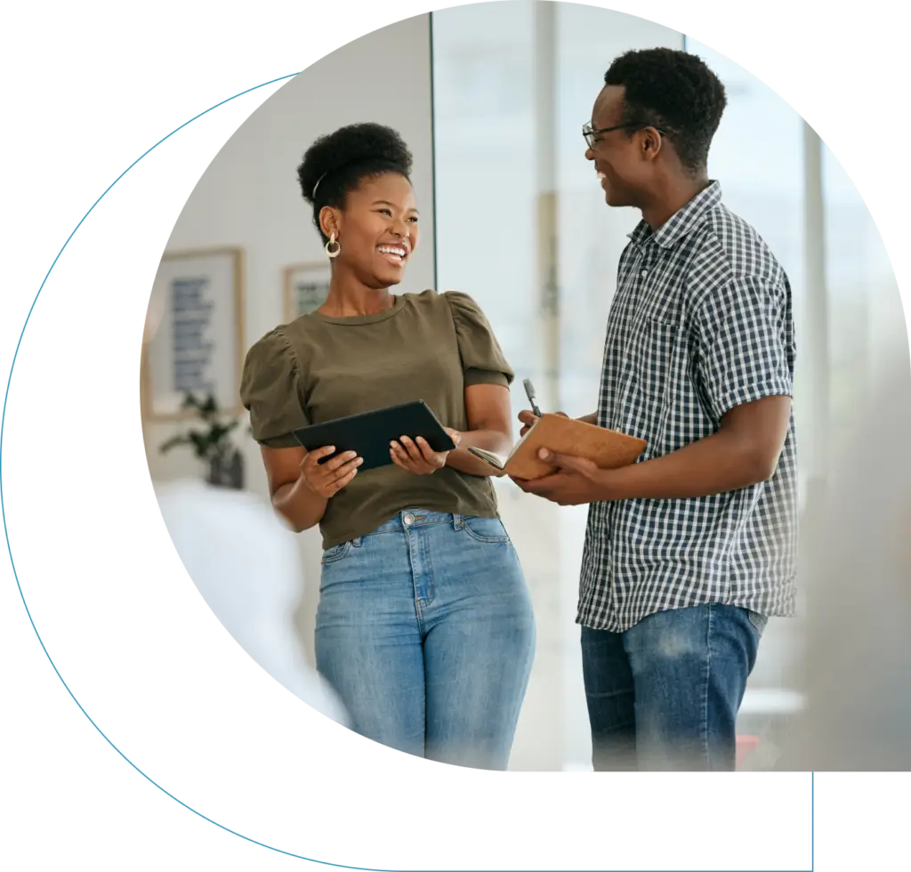 Woman with her tablet and man with his notebook happily chatting while standed