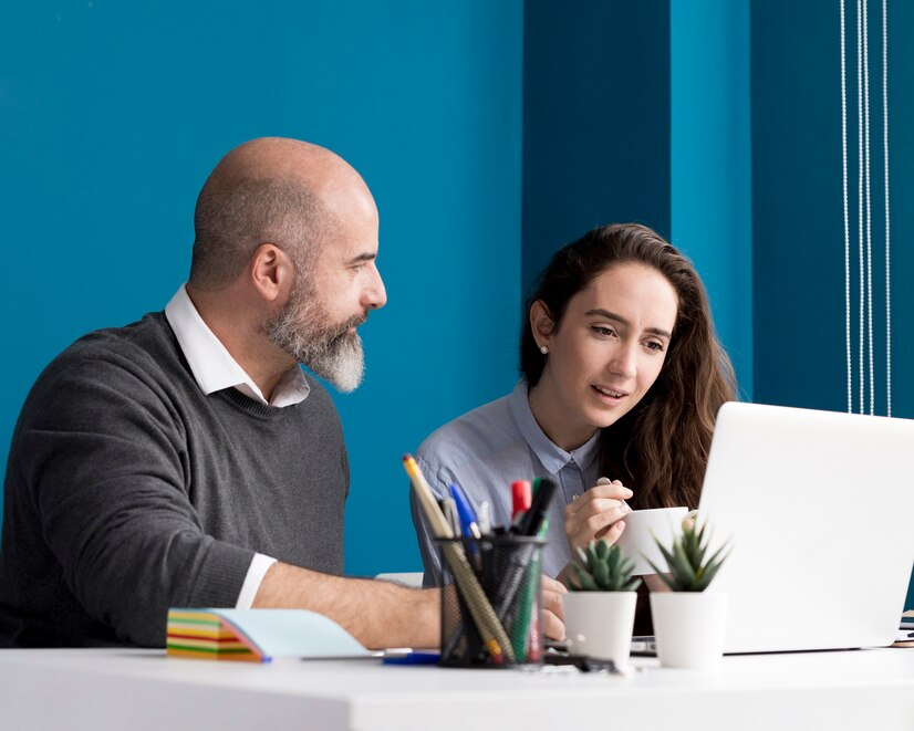 Man and woman working together with their laptop in the office